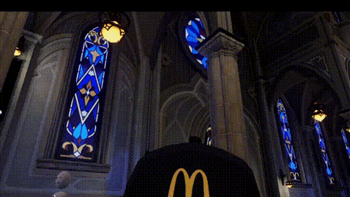a person wearing a mcdonald 's hat is standing in front of a stained glass window in a church .