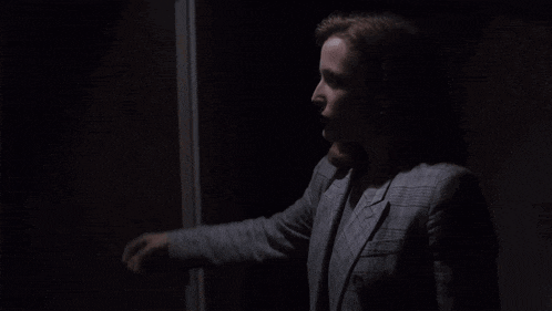a woman standing in a dark room with the words " the fbi 's most unwanted " written on the bottom