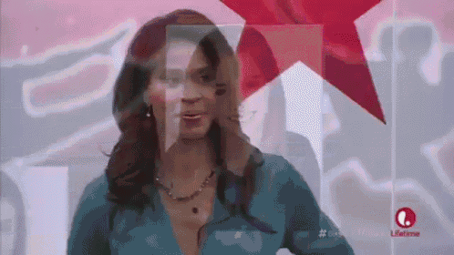a woman in a blue shirt is standing in front of a red star on a white background .