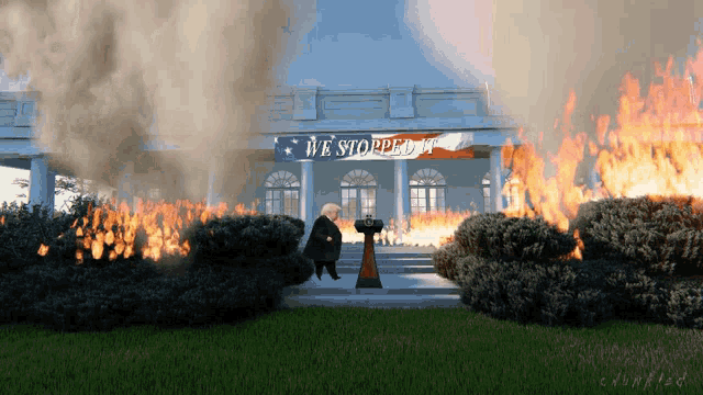 a man stands in front of a burning white house with a banner that says we stopped it
