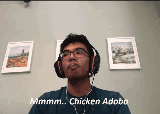 a man wearing headphones says " chicken adobo " in front of paintings