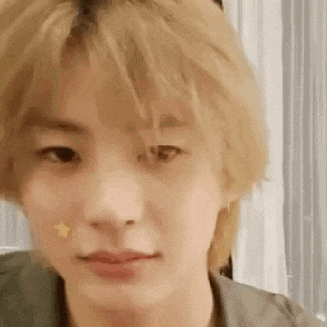 a close up of a person 's face with a star on his cheek .