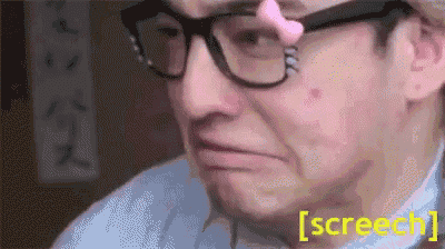 a man wearing glasses and a pink nose ring is crying .