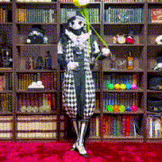 a man in a clown costume is standing in front of a bookshelf holding a flower ..