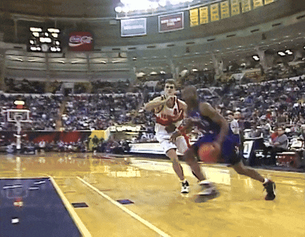 a coca cola sign hangs from the ceiling of a basketball court