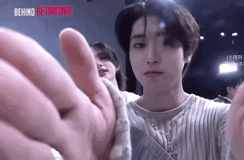 a close up of a person 's hand reaching out towards another person 's face .