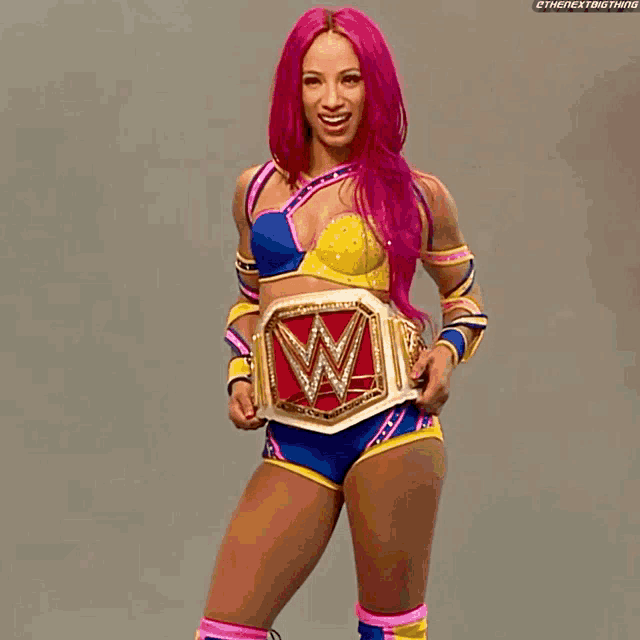 a woman with pink hair is wearing a wwe belt
