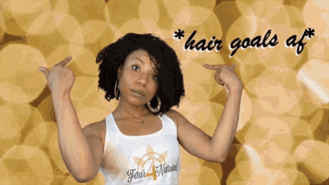 a woman wearing a tank top that says four natural points at her hair