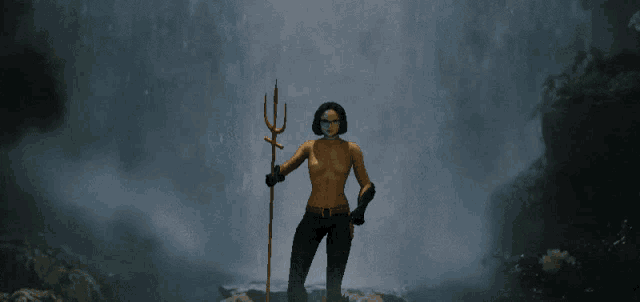 a naked woman holding a trident standing in front of a waterfall