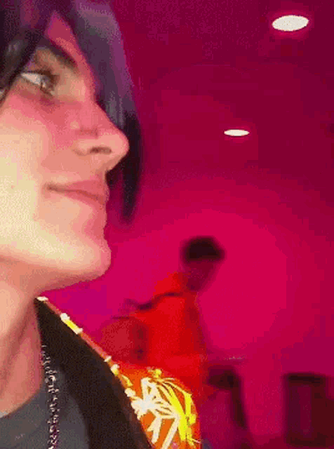 a close up of a person 's face against a pink wall