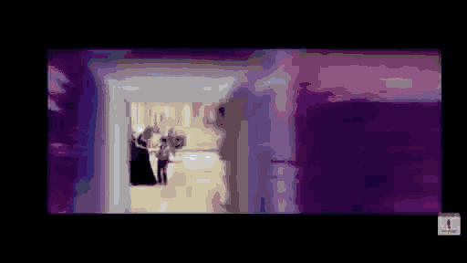 a blurry picture of a person walking down a hallway .