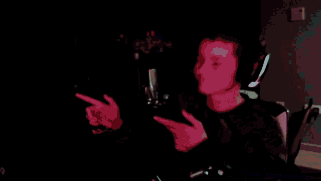 a person wearing headphones is pointing at something