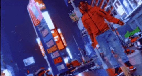 a man in an orange jacket is dancing in front of a sign that says empire