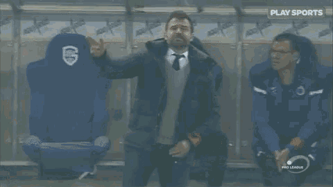 a man with his arms outstretched stands in front of a locker room that says aquarius