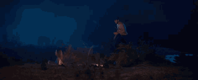 a fire is burning in a field at night with smoke coming out of it