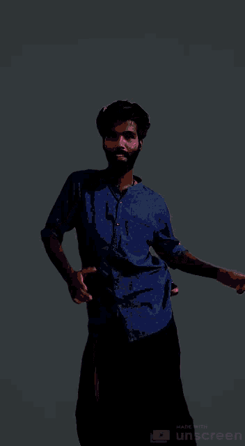 a man in a blue shirt is standing in front of a purple and pink background