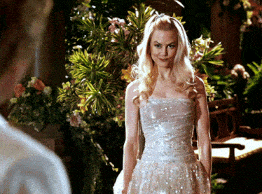a woman in a white dress stands in front of a man