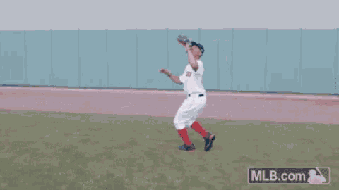 a man wearing a red sox jersey stands on the field