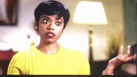 a woman in a yellow sweater is making a funny face