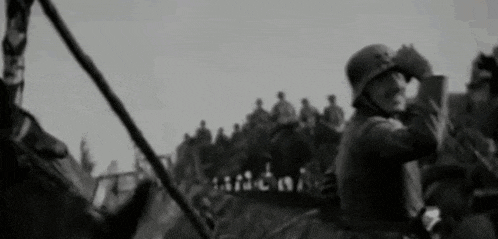 a man in a helmet is looking through binoculars in front of a crowd of people