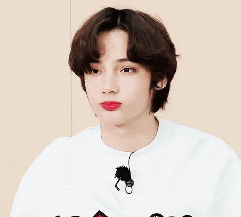 a close up of a person wearing a white shirt with korean writing