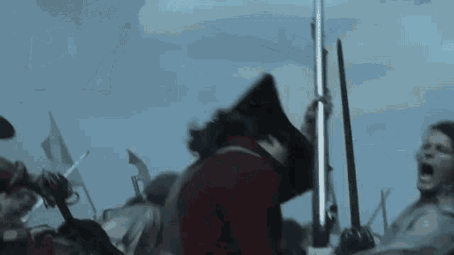 a group of soldiers are fighting each other in a battle with swords and guns .