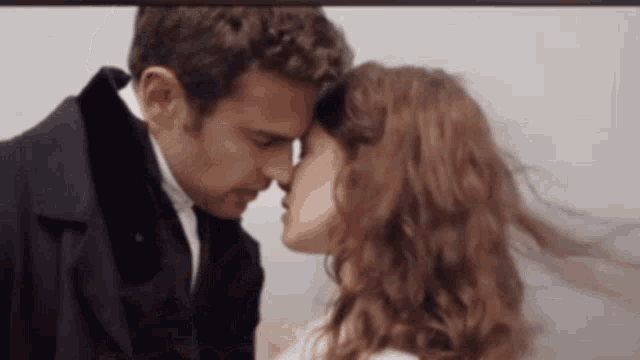 a man and a woman are kissing each other .