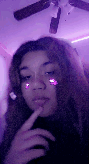 a girl is taking a picture of herself in a room with a ceiling fan .