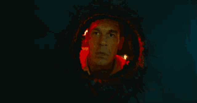 a man is looking through a hole in a dark room