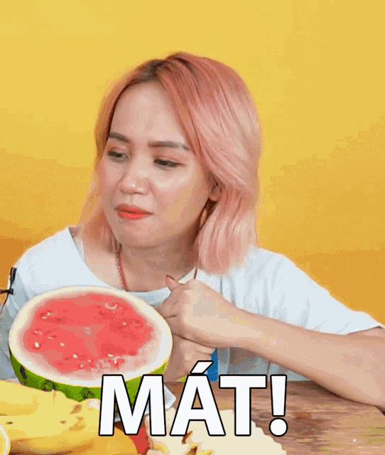 a woman with pink hair is eating a slice of watermelon with the words mat written on it