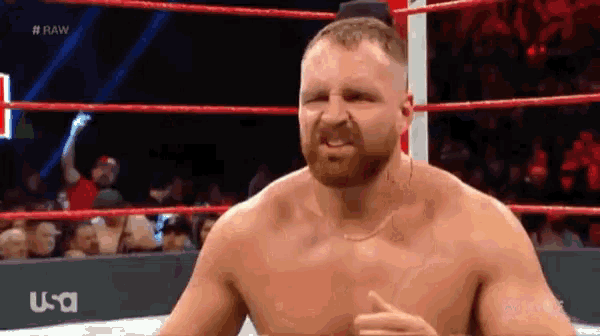 a shirtless wrestler is standing in a wrestling ring with a usa logo behind him