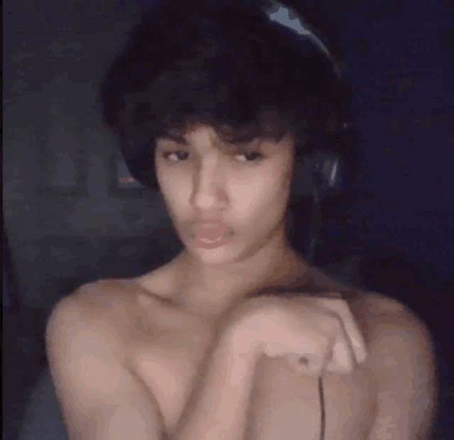 a shirtless young man wearing headphones and a ring on his finger .