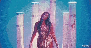 a woman in a red dress is covered in blood and standing in front of columns .