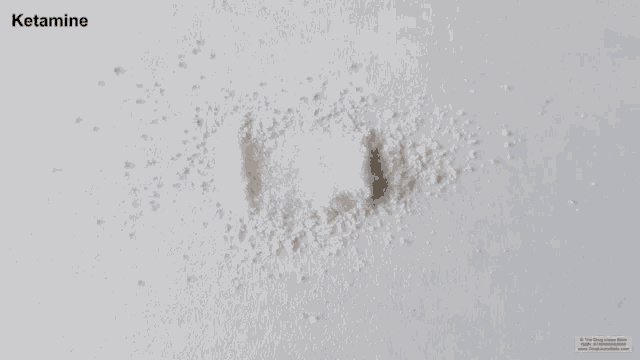 a pile of white powder with the word ketamine on it