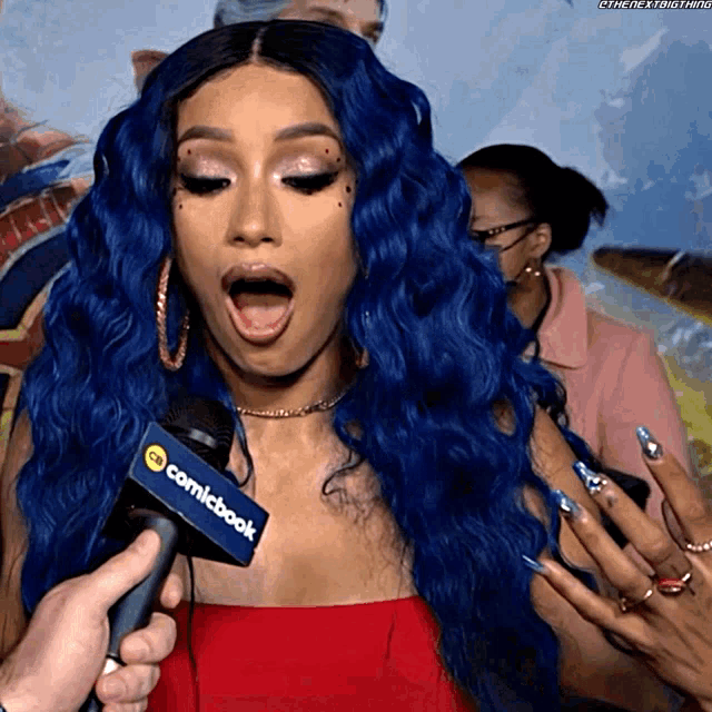 a woman with blue hair is being interviewed by a comicbook microphone