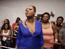 a woman in a blue top is standing in front of a crowd