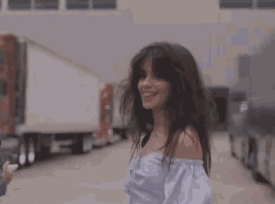 a woman is sticking her tongue out while standing on a street .