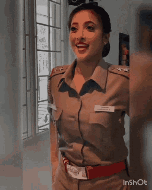 a woman in a police uniform is smiling and wearing a name tag that says ' s.s. ' on it