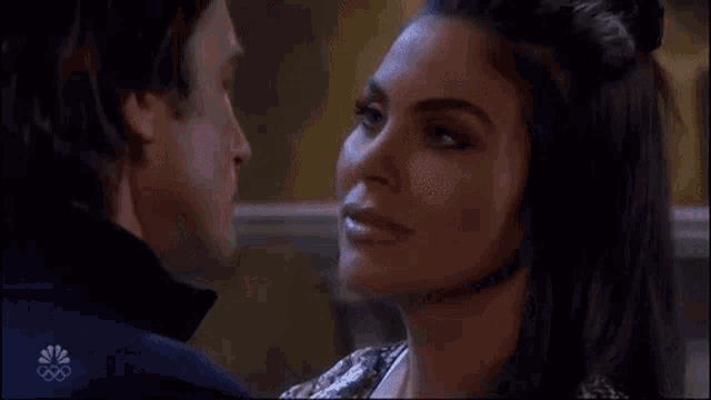 a man and a woman are looking into each other 's eyes and smiling .