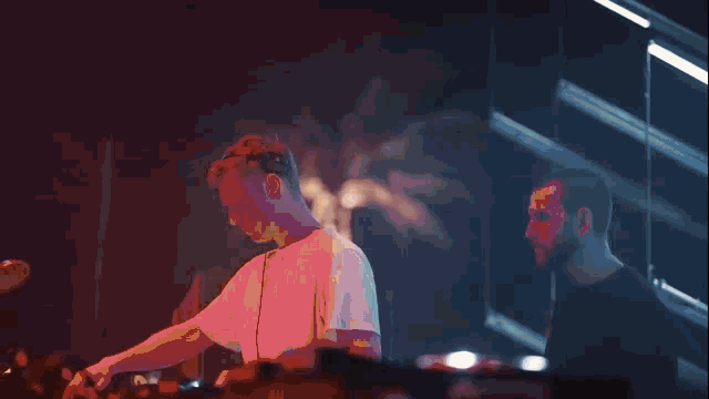 a man playing a pioneer keyboard while another man looks on