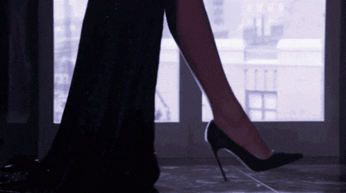 a woman in a long black dress and black high heels