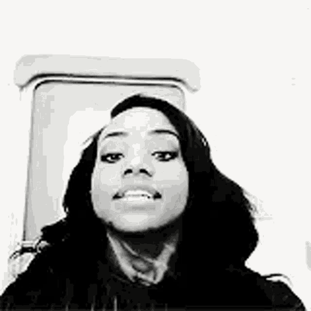 a black and white photo of a woman taking a selfie in front of a toilet .