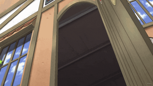 looking up at a building with the door open and a blue sky in the background