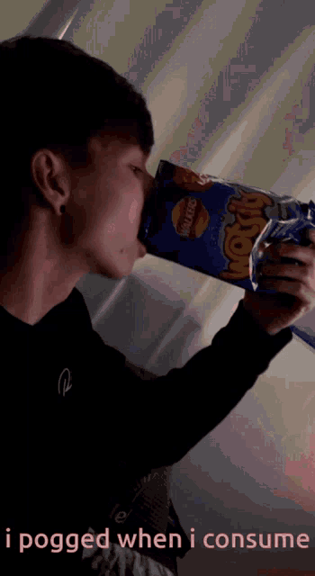 a young man drinks from a bag of lays chips