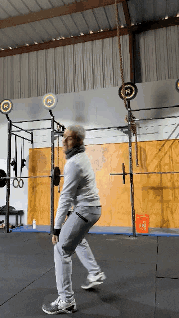 a man in a gym with a bucket that says lg