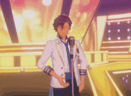 a man in a suit is standing in front of a microphone on a stage .