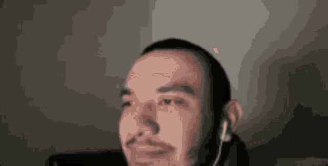 a man with a beard is wearing headphones while looking at the camera .