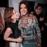two women are standing next to each other at a party .