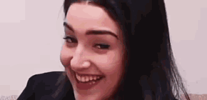 a close up of a woman 's face smiling and making a funny face .