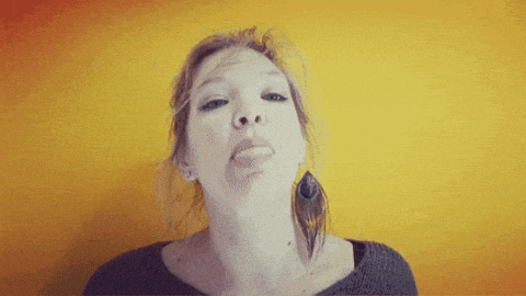 a woman making a funny face against a yellow background
